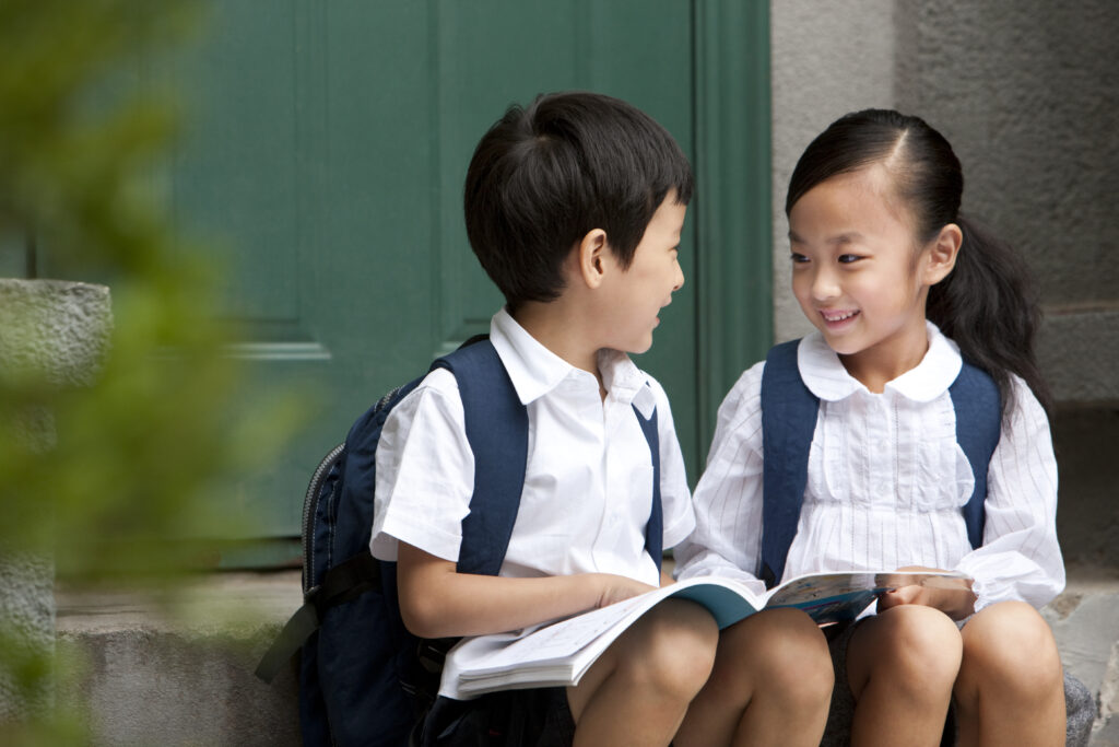 Two-asian-kids-smiling-while-studying-primary-math-tuition