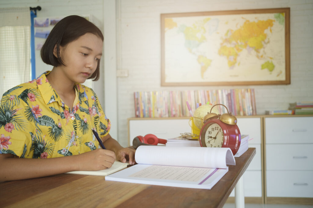 an image of a female student answering a timed paper practice exam using her O level chemistry study guide