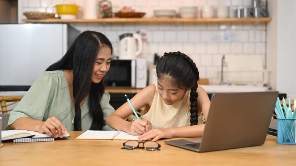 Parent and child reviewing a PSLE maths problem sum together at home