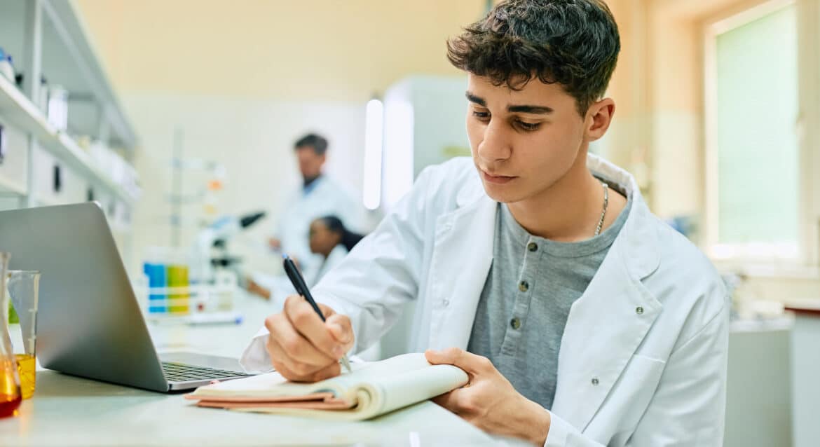 Secondary student working through an O Level Chemistry study guide with written practice questions